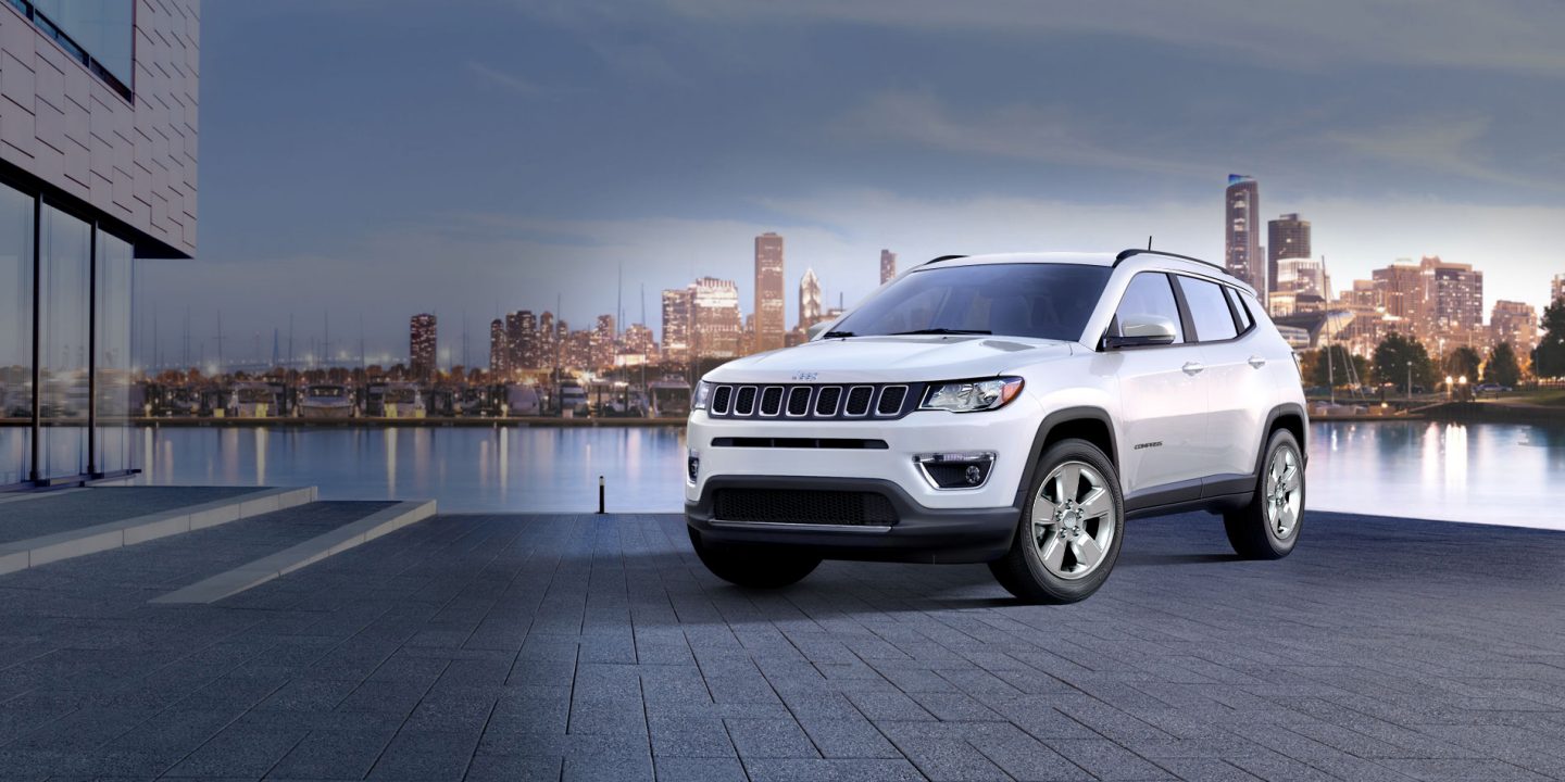 A three-quarter front view of a 2021 Jeep Compass Trailhawk being driven in snow.